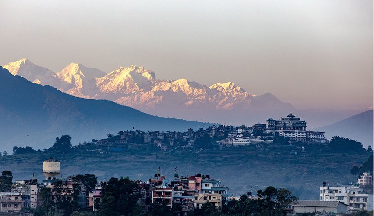 Himalayan valley town with snow ridges